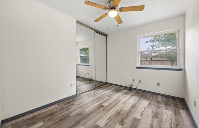 empty room with ceiling fan and light hardwood / wood-style floors