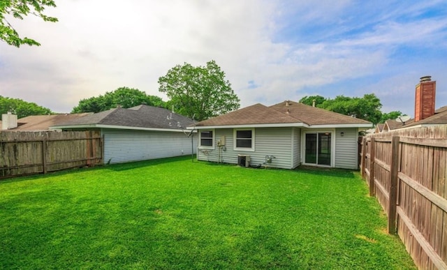 rear view of house featuring a lawn and cooling unit