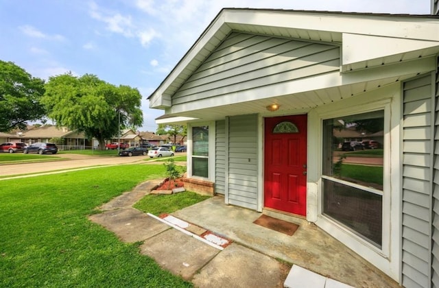 view of exterior entry featuring a yard