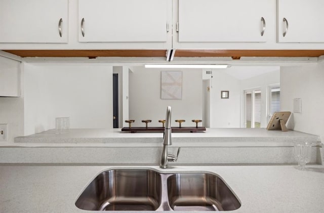 kitchen featuring white cabinets and sink