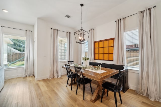 dining area featuring a wealth of natural light, an inviting chandelier, and light hardwood / wood-style floors