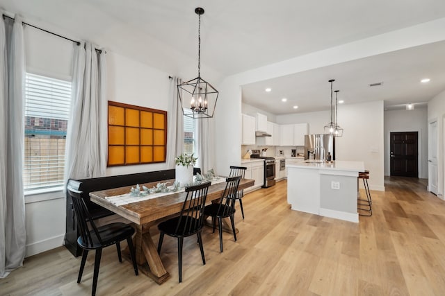 dining room featuring an inviting chandelier and light hardwood / wood-style flooring