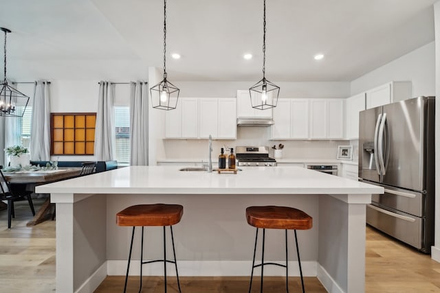 kitchen with stainless steel appliances, a wealth of natural light, white cabinetry, and light hardwood / wood-style floors