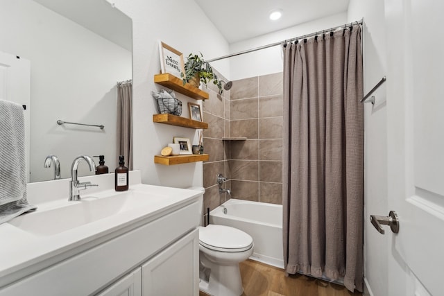 full bathroom featuring hardwood / wood-style flooring, shower / tub combo with curtain, vanity, and toilet