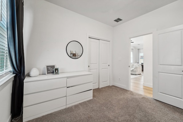 unfurnished bedroom featuring light colored carpet and a closet