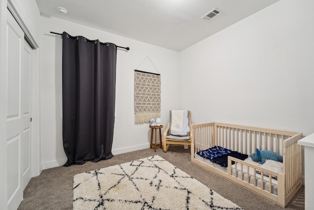 bedroom featuring a closet, carpet, and a nursery area