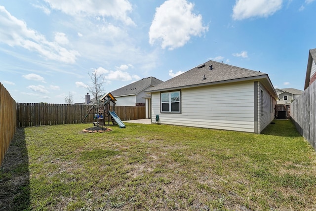 rear view of property featuring a playground and a yard