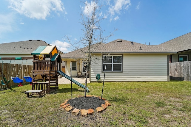 back of house with a playground and a lawn