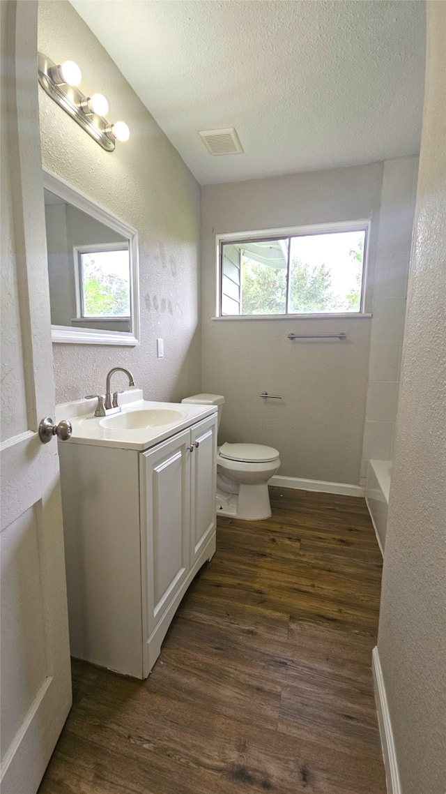 full bathroom with plenty of natural light, vanity, toilet, and hardwood / wood-style flooring