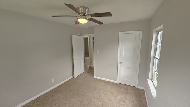 unfurnished bedroom with light colored carpet and ceiling fan