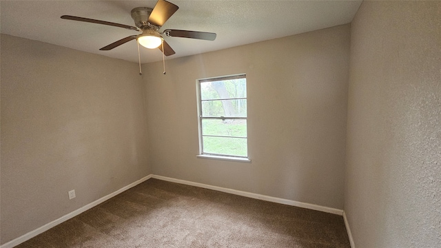 spare room featuring dark carpet and ceiling fan