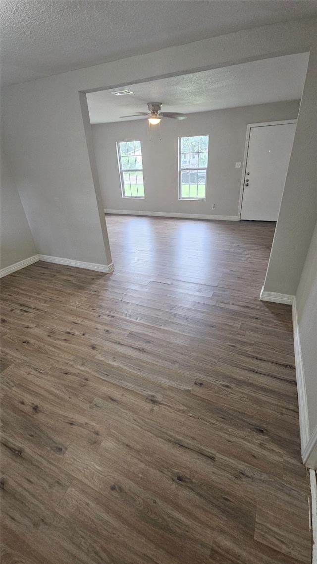 interior space with ceiling fan, dark hardwood / wood-style floors, and a textured ceiling