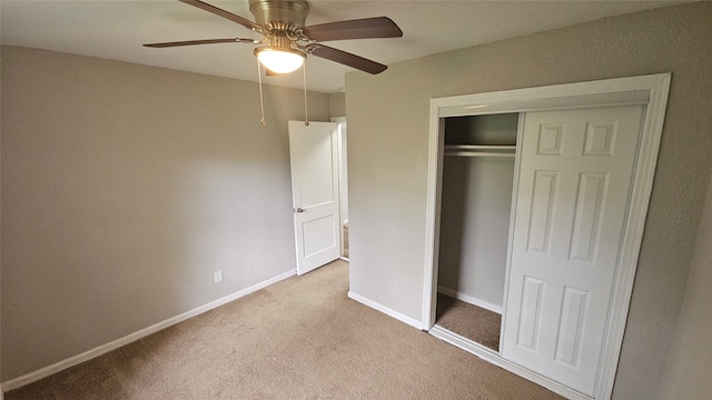 unfurnished bedroom with light colored carpet, ceiling fan, and a closet