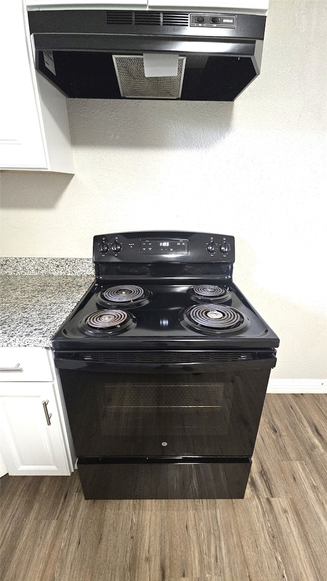 interior details with ventilation hood, light stone countertops, electric range, white cabinetry, and wood-type flooring