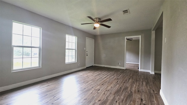 spare room with a wealth of natural light, ceiling fan, dark hardwood / wood-style floors, and a textured ceiling