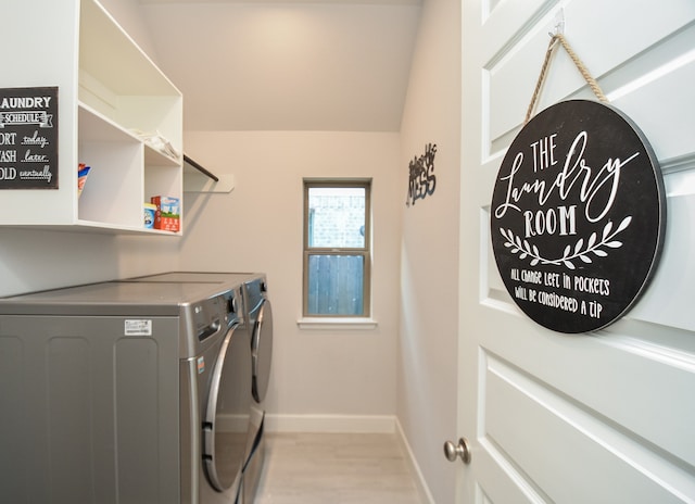 laundry area featuring washing machine and dryer and light hardwood / wood-style floors