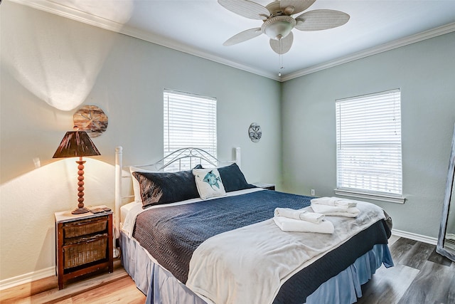 bedroom with multiple windows, wood-type flooring, and ceiling fan