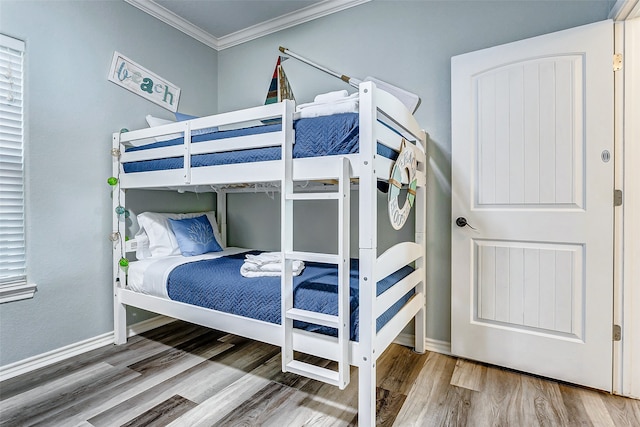 bedroom with crown molding and hardwood / wood-style flooring