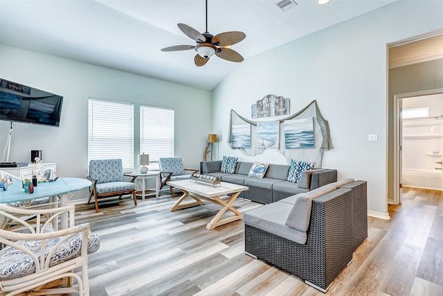 living room with lofted ceiling, ceiling fan, and light wood-type flooring