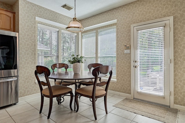 dining room with wallpapered walls, baseboards, light tile patterned floors, and visible vents