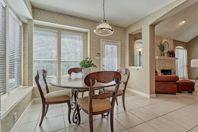 dining area with wallpapered walls, plenty of natural light, a fireplace, and baseboards