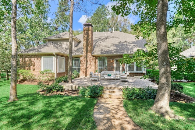 back of property with an outdoor hangout area, brick siding, a lawn, a chimney, and a patio area