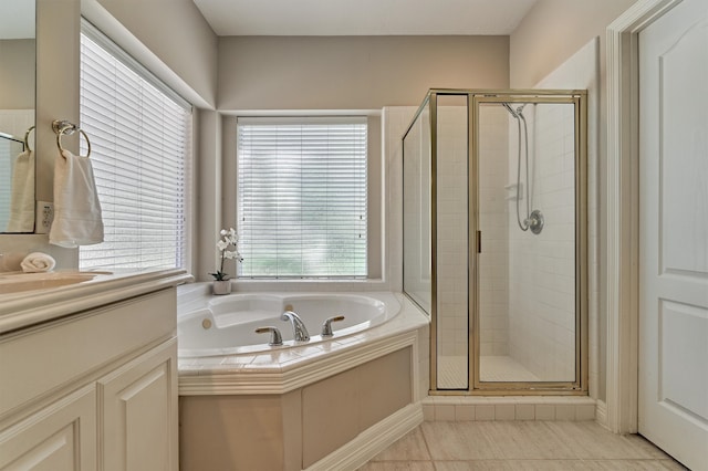 bathroom with tile patterned flooring, a shower stall, a bath, and vanity