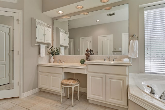 bathroom with double vanity, a healthy amount of sunlight, and a sink