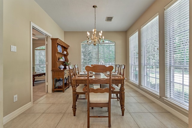 dining area with visible vents, an inviting chandelier, light tile patterned flooring, a textured ceiling, and baseboards