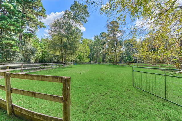 view of yard with a rural view and fence