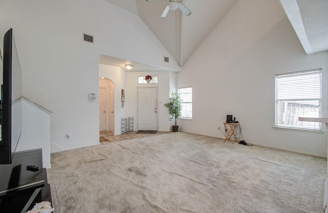 entryway with light carpet, high vaulted ceiling, and ceiling fan