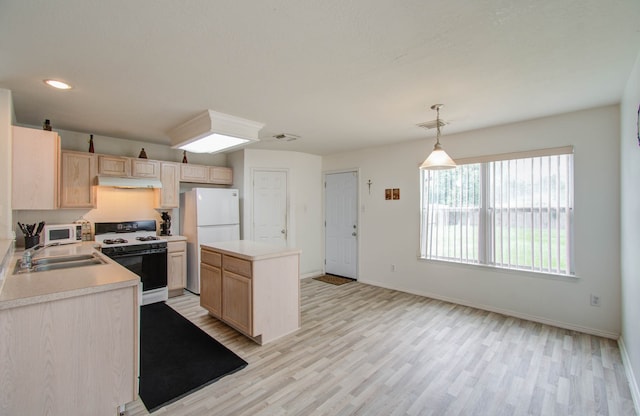 kitchen with pendant lighting, light brown cabinetry, sink, and white appliances