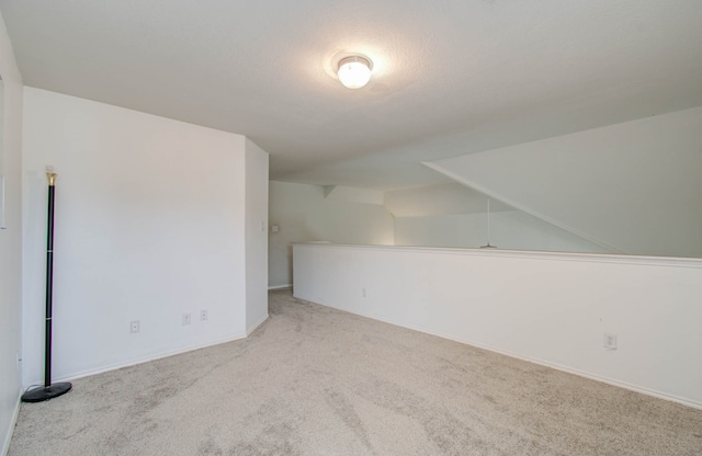 additional living space with light carpet and vaulted ceiling