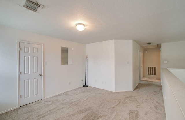 carpeted spare room with a textured ceiling