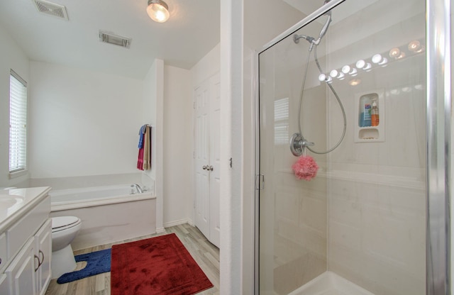 full bathroom featuring shower with separate bathtub, toilet, hardwood / wood-style flooring, and vanity