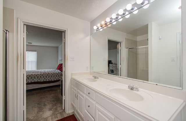 bathroom with vanity, a textured ceiling, hardwood / wood-style floors, and a shower with door