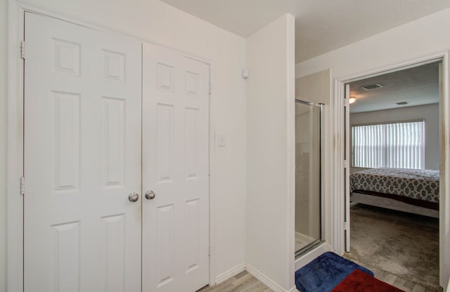 interior space featuring an enclosed shower and hardwood / wood-style flooring