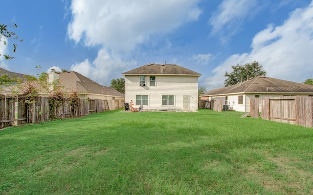 rear view of property with a yard