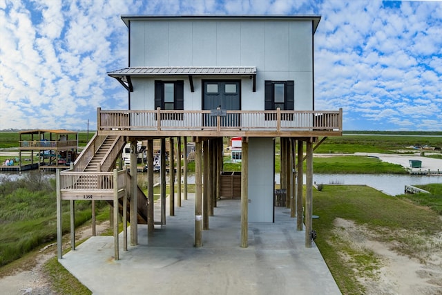 view of front of home with a deck with water view and a carport