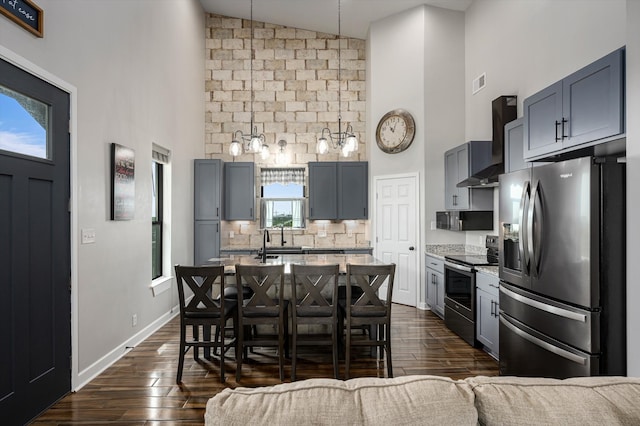 kitchen featuring a breakfast bar, appliances with stainless steel finishes, plenty of natural light, and wall chimney range hood