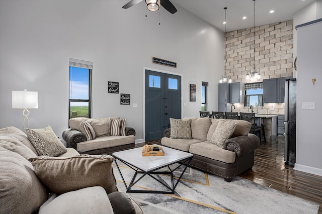 living room with dark hardwood / wood-style floors, ceiling fan, and high vaulted ceiling