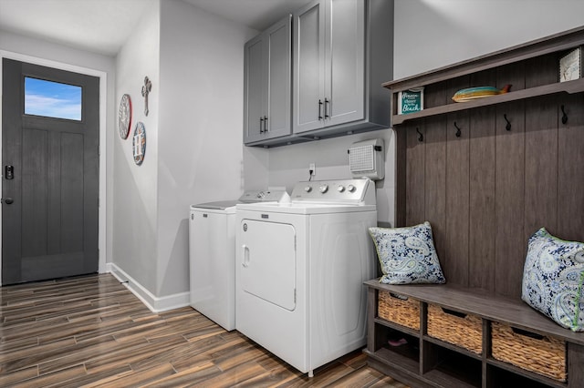 laundry room with independent washer and dryer, dark wood-type flooring, and cabinets