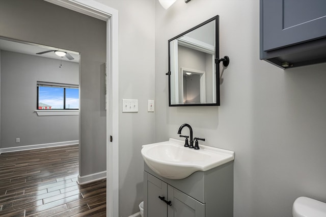 bathroom with wood-type flooring, vanity, and toilet