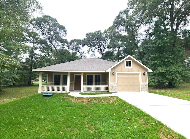 view of front of property with a garage, a front lawn, and covered porch