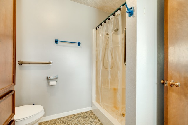 bathroom with tile patterned flooring, toilet, curtained shower, and a textured ceiling