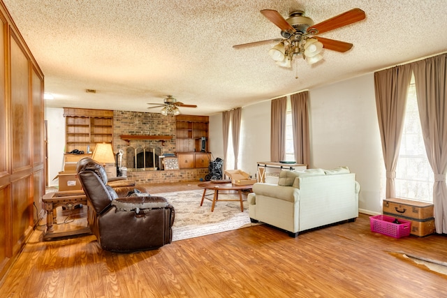 living room featuring plenty of natural light, a fireplace, and light hardwood / wood-style flooring