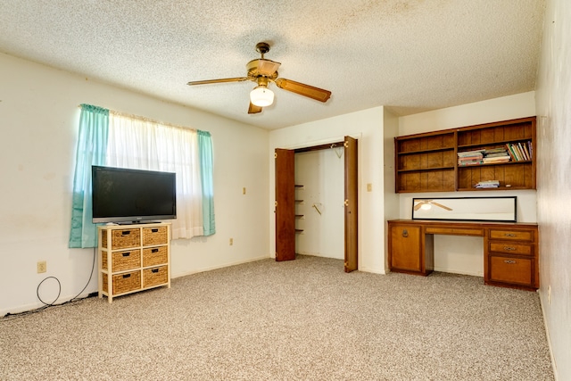 living room with ceiling fan, light carpet, and a textured ceiling