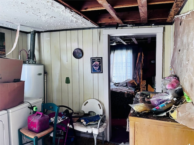 miscellaneous room with gas water heater, washer and clothes dryer, and wooden walls