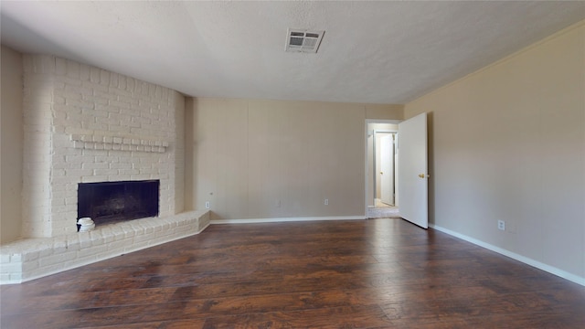 unfurnished living room with a textured ceiling, a fireplace, and dark hardwood / wood-style flooring