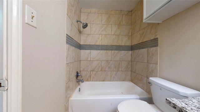 bathroom featuring tiled shower / bath and toilet